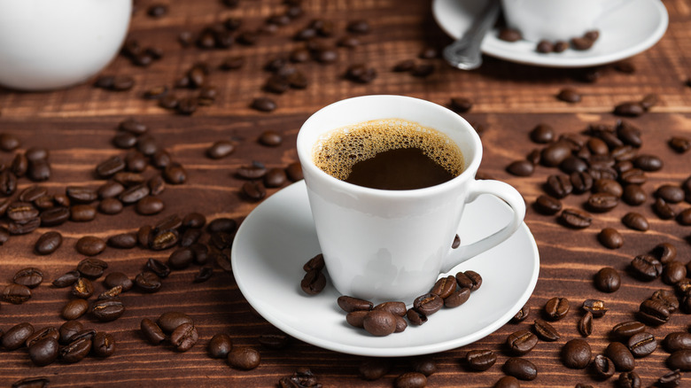 a cup of coffee surrounded by coffee beans