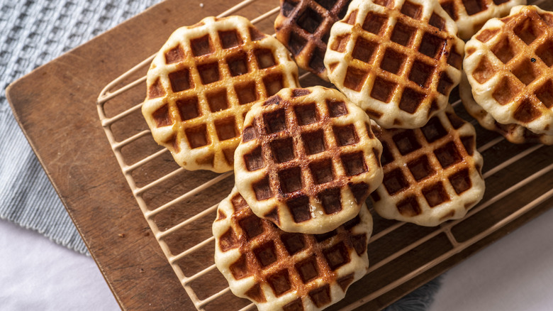 Waffles on a wire rack over a wooden board