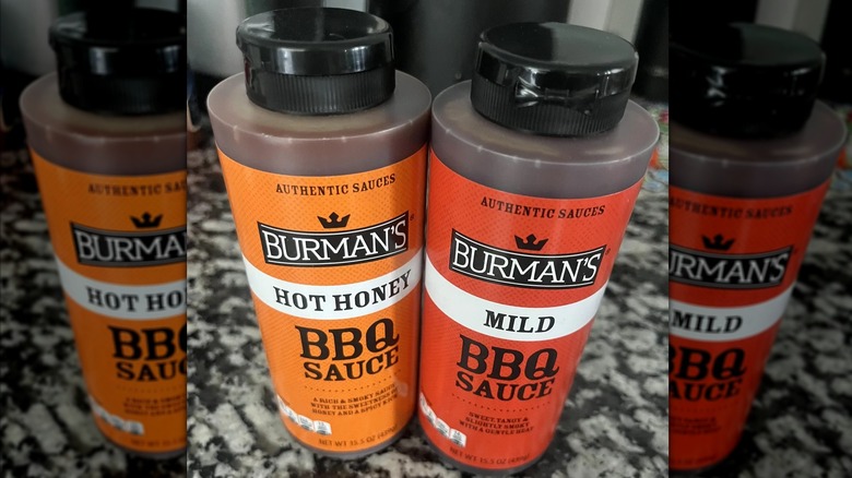 Burman's Hot Honey and Mild barbecue sauces on a marbled countertop