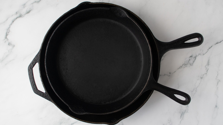 Small cast iron skillet stacked onto larger cast iron skillet