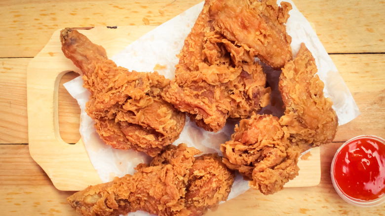 Crispy fried chicken on a wax paper covered cutting board