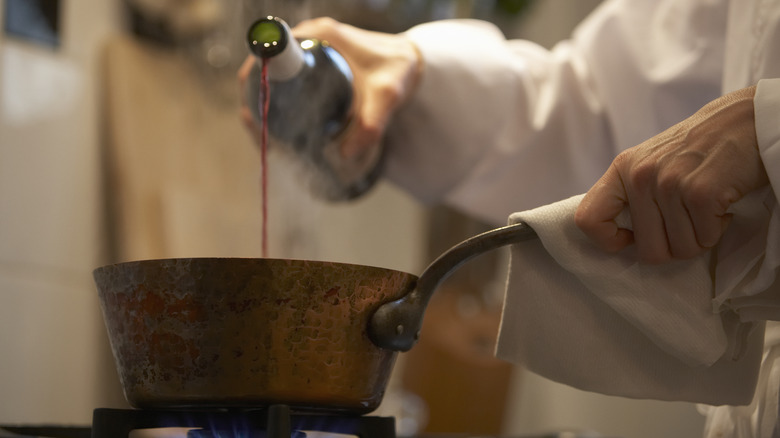Pouring wine into a pot