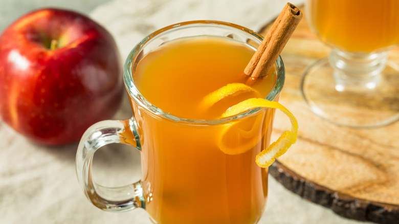 A downward view of a classic hot toddy with a cinnamon stick and lemon rind garnish