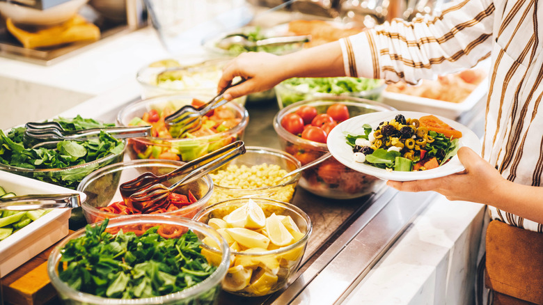 a person selecting food from a buffet