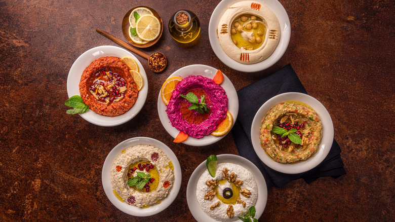Assortment of colorful dips in small bowls