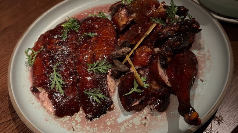 Mr. Jiu's famous Peking-style duck roast, looking incredibly juicy, served on a plate