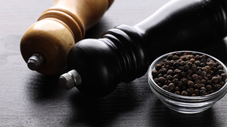 Two pepper mills with whole peppercorns