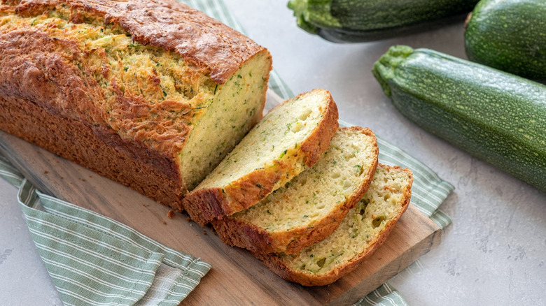 A sliced loaf of zucchini bread on a cutting board