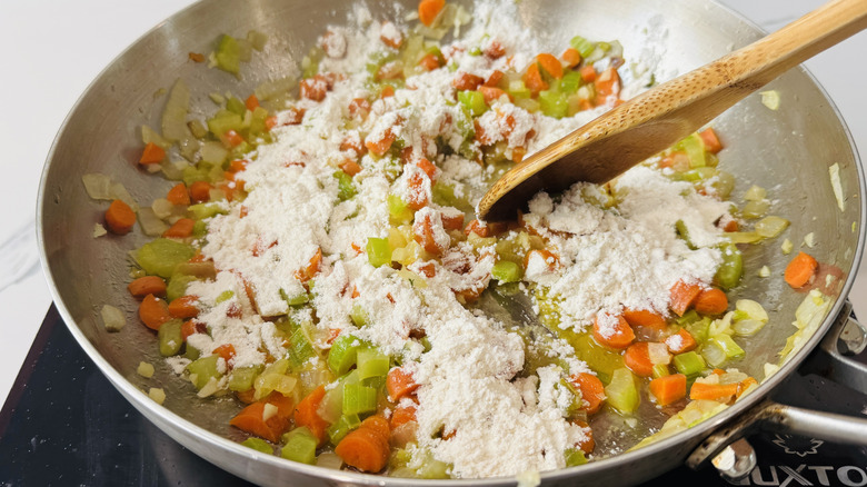 Stirring flour into skillet veggies