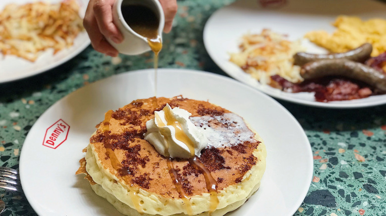 Fluffy Denny's pancakes drizzled with rich maple syrup