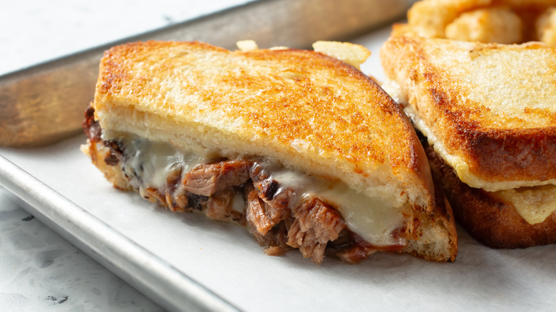 A closeup of a grilled cheese sandwich with beef inside