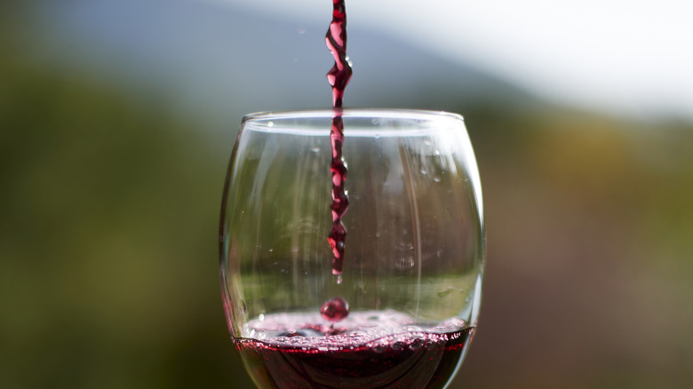wine glass filling with red wine
