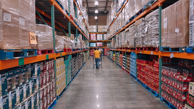 Customer pushing down a cart along Costco aisle