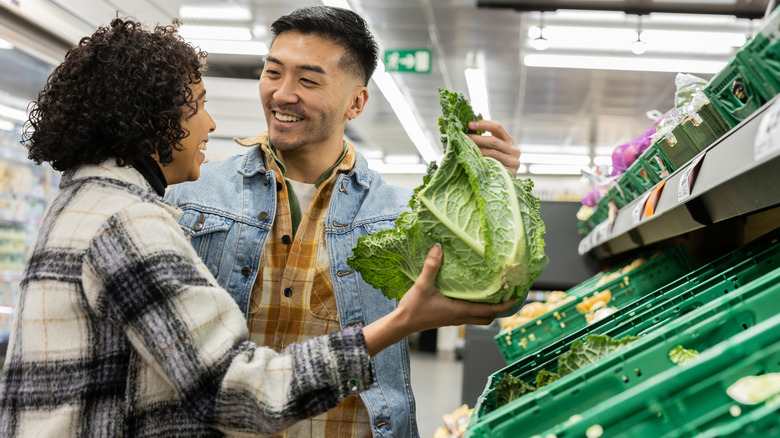 Young couple shopping for lettuce at a grocery store