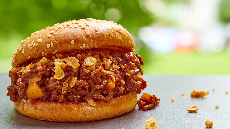 Juicy sloppy Joe sandwich with ground beef on gray stone.