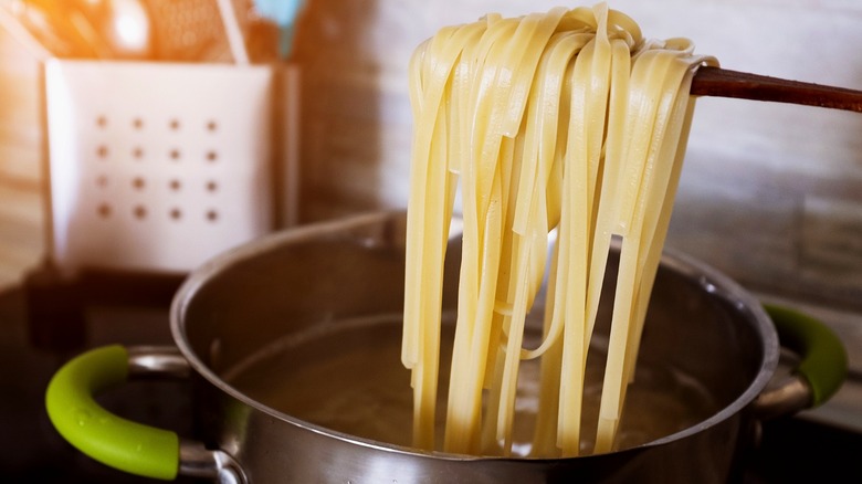 Linguini being lifted from large pot of water
