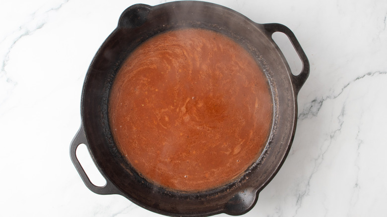 reddish-brown liquid in a black frying pan