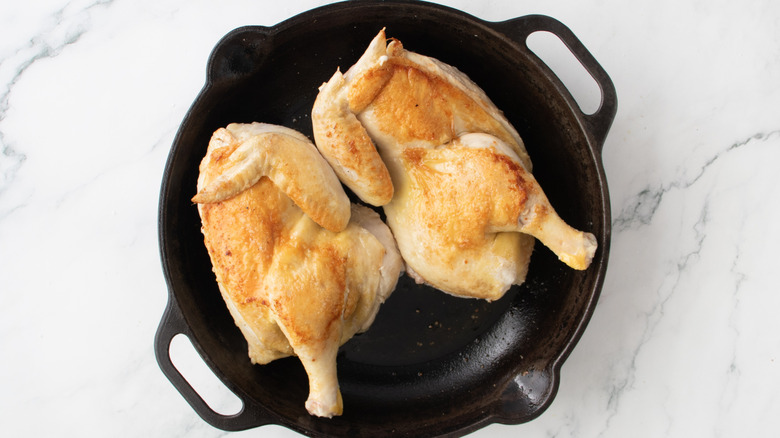 browned chicken in a black frying pan