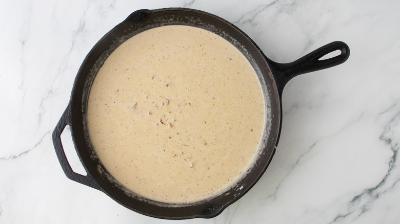 orangish creamy liquid in a black frying pan