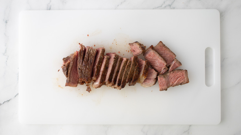sliced steak on a white board