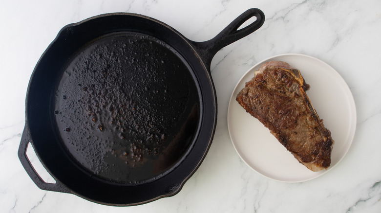 steak next to a black frying pan