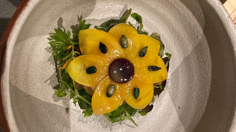 Plant salad with fruit cut into the shape of a sunflower