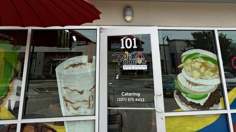 Patacon Latin Cuisine's colorful facade with illustrations of its offerings on the expansive windows