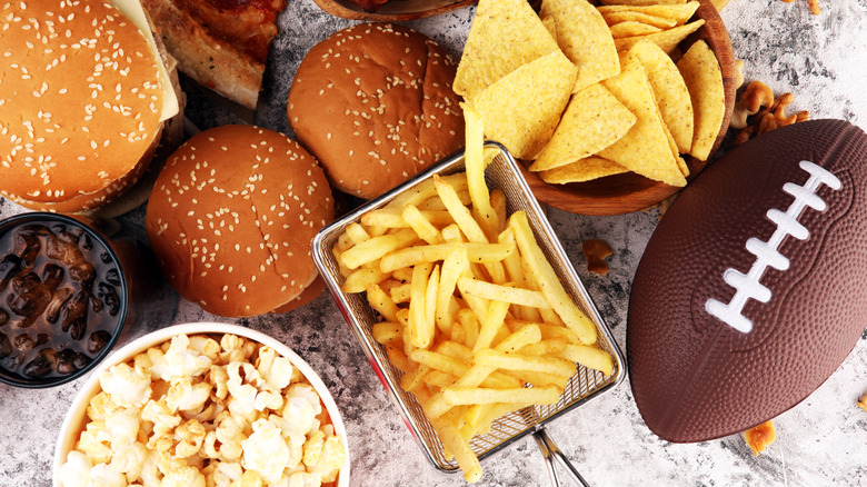 Various game day food items next to an American football