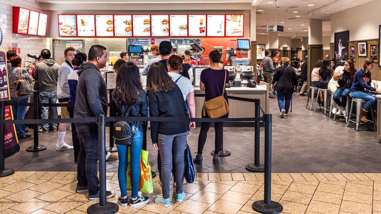 Customers line up at busy fast food restaurant.