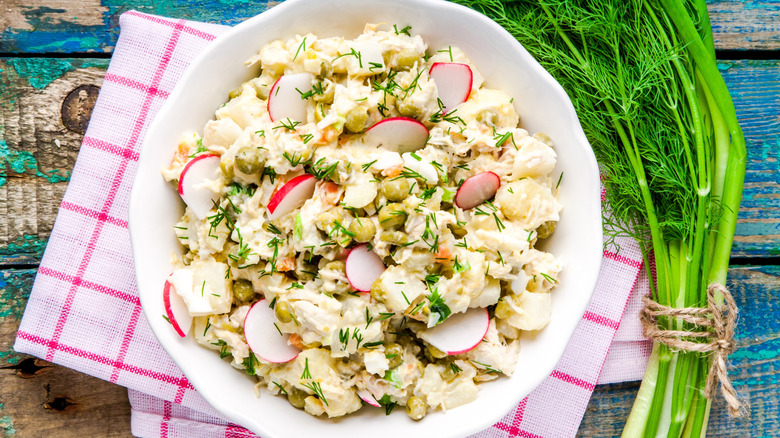 A bowl of potato salad is photographed from overhead.
