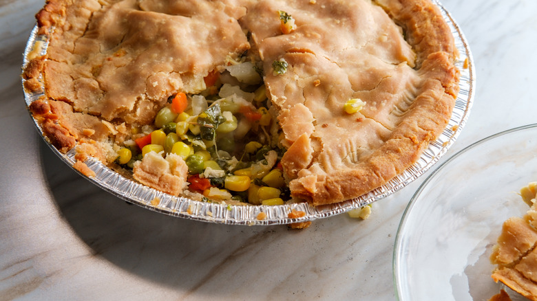Chicken pot pie in foil pan with one missing slice