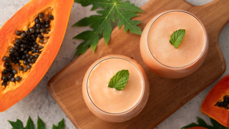 Glasses of papaya milk on a board