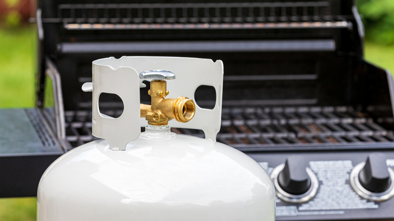Propane tank in front of a gas grill