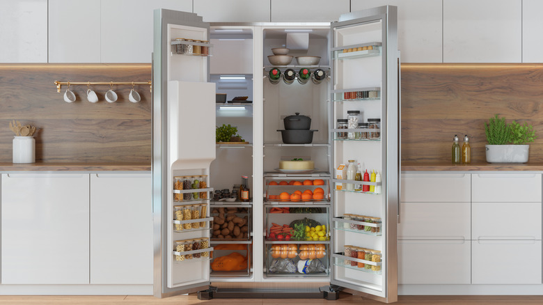 A French-doored refrigerator and freezer is pictured open in a home kitchen.