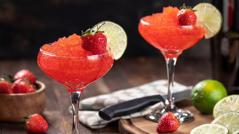 Two frozen strawberry daiquiris are served in fancy glasses