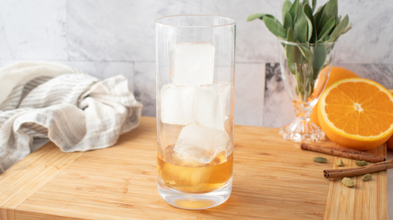 ice cubes and orangish-brown liquid in a tall glass