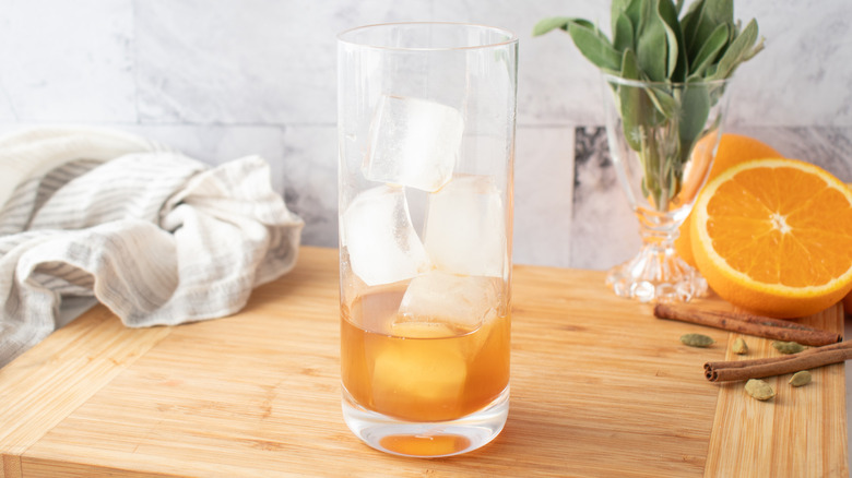ice cubes and orangish-brown liquid in a tall glass