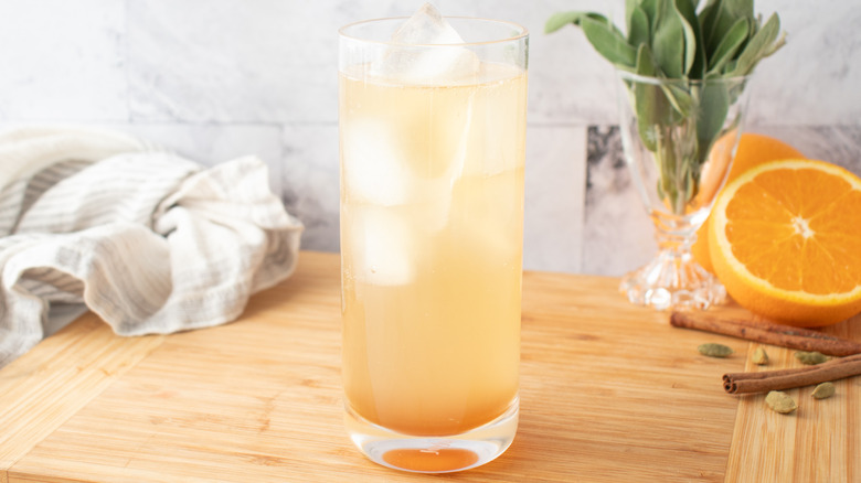 pale, orange-colored cocktail in a tall glass with ice