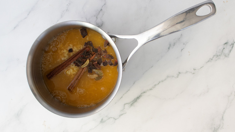 orange juice and spices in a metal pot