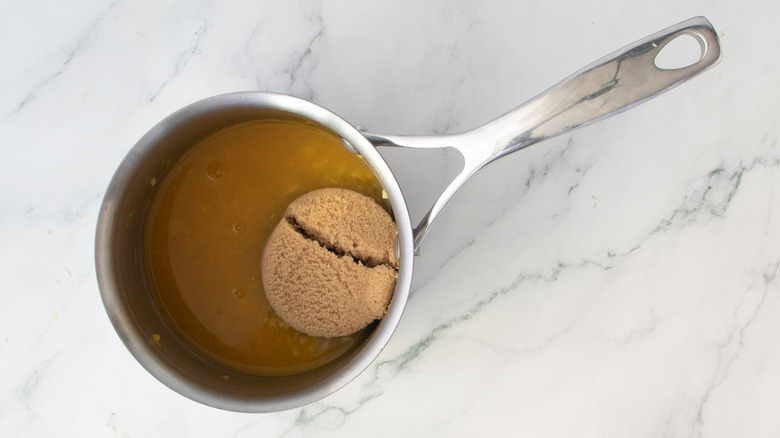 orange juice and brown sugar in a metal pot