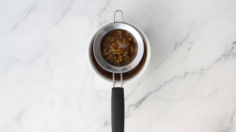 strainer sitting above a white bowl