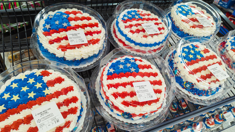 Display of red white and blue iced American flag themed cakes and cupcakes on Walmart bakery shelf