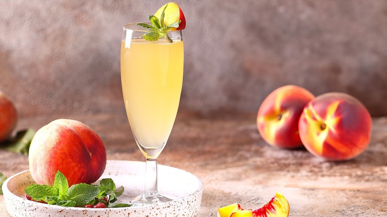 Bubbly peach cocktail in a tall clear glass