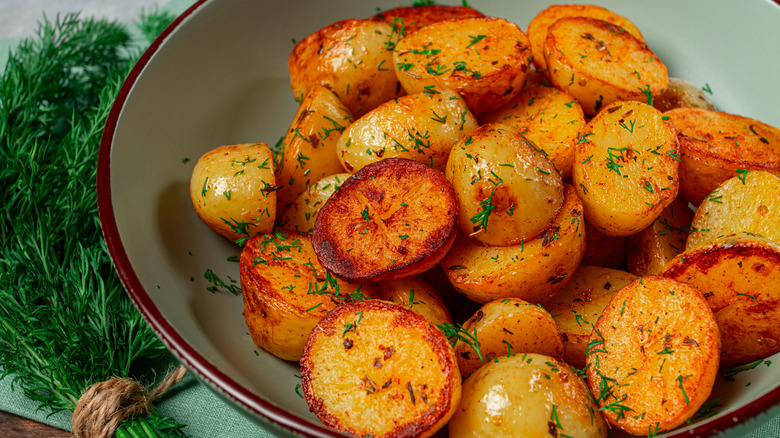 Roasted potatoes in a bowl sprinkled with chopped dill