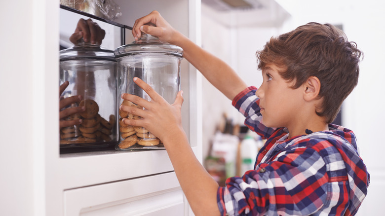 A young boy gathers his own snacks from a pantry