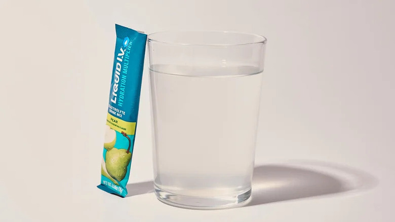 Pear Liquid I.V. satchet and empty glass of water