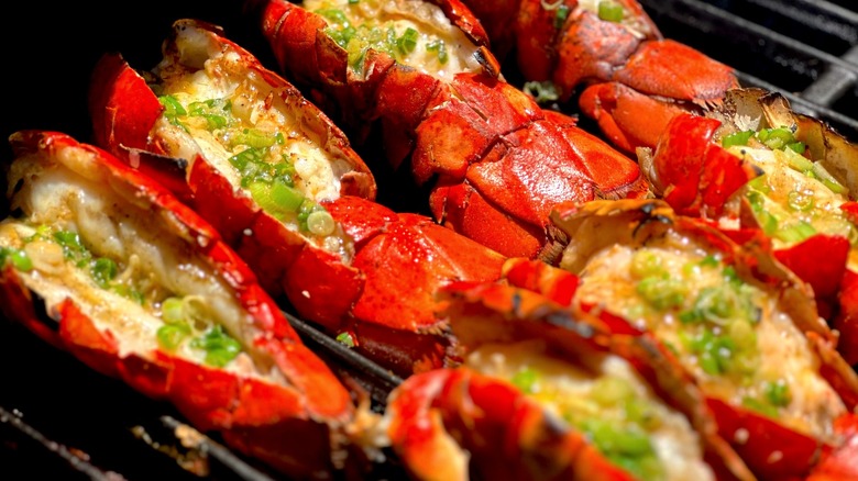 Lobster tails heating on a grill.