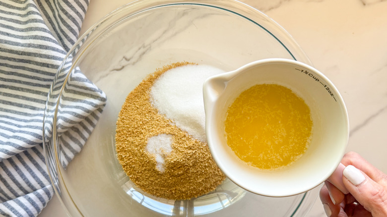 hand adding butter to bowl