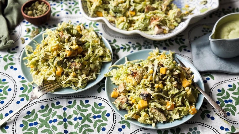 Chopped mango avocado chicken salad on plates with forks