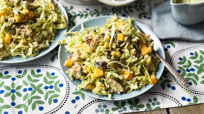 Chopped mango avocado chicken salad on plates with fork